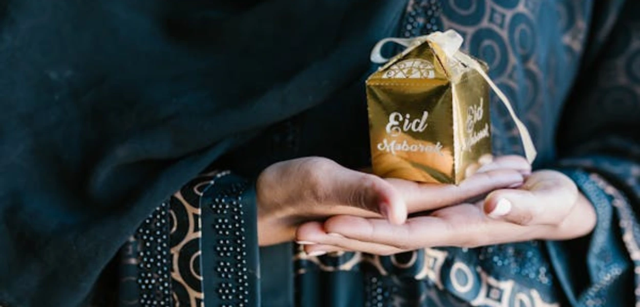 Gambar cewek membawa bingkisan bertuliskan Eid Mubarak
