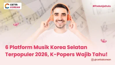 Seorang pria menggunakan headphone orange mendengarkan musik korea melalui salah satu platform musik korea selatan populer 2026